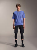 Alpinestars A-Aria Lite Short, short de VTT pour homme, noir, porté avec un maillot à manches courtes violet clair et des genouillères noires, vêtement de VTT performance