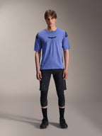 Alpinestars A-Aria Lite Short, short de VTT pour homme, noir, porté avec un maillot à manches courtes violet clair et des genouillères noires, vêtement de VTT performance