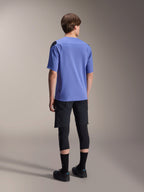 Alpinestars A-Aria Polartec Elite Short Sleeve Jersey in Baja Blue, back view on a male model, paired with black MTB shorts and knee protection, featuring a performance fit and dropped rear hem for trail riding.