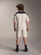 Maillot à manches courtes Alpinestars A-Aria Polartec Elite, maillot de cyclisme VTT, écru avec empiècements noirs aux épaules, vue de dos avec short assorti et chaussettes noires, coupe performance avec un design à queue tombante pour le tout-terrain.