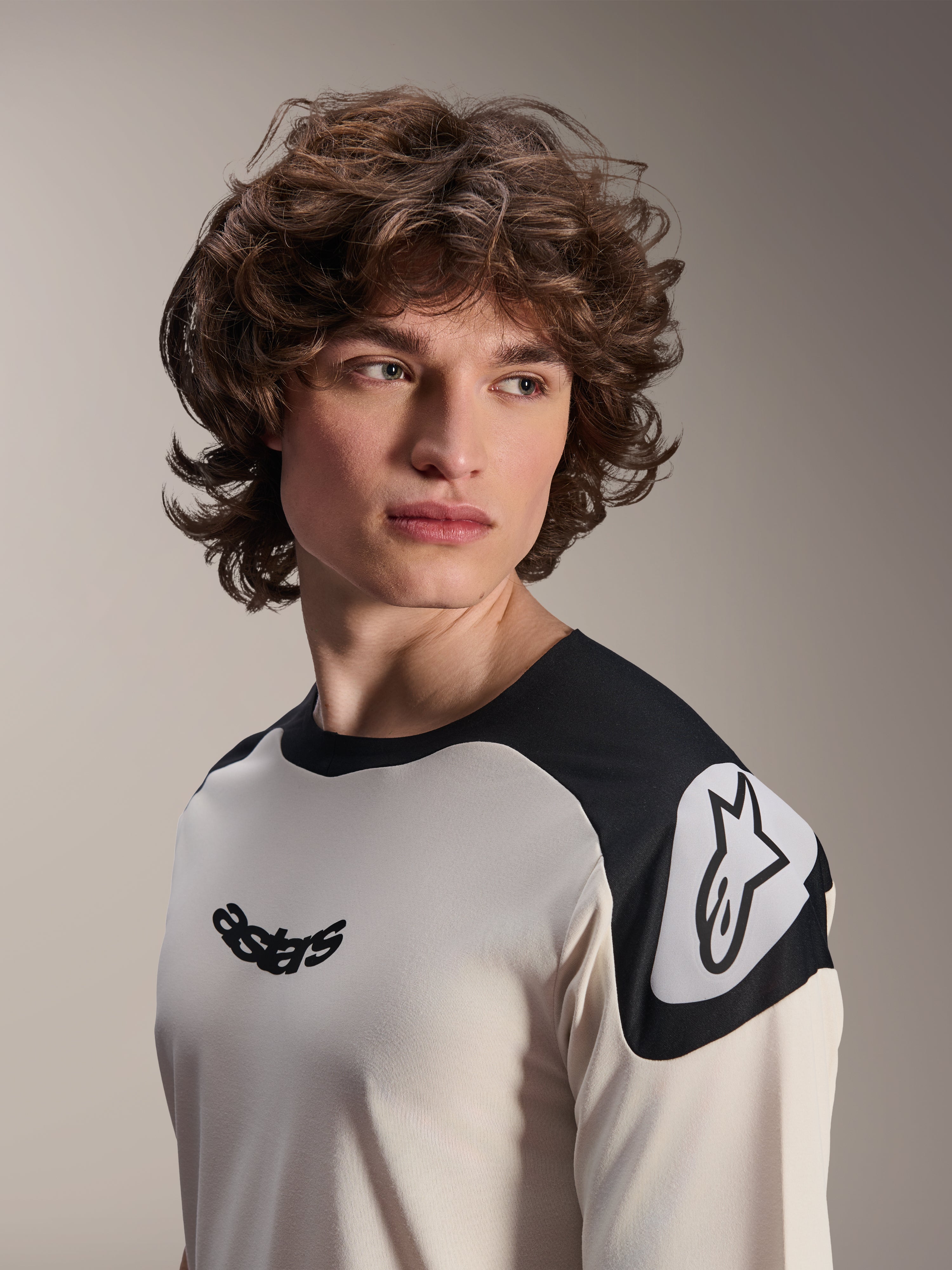 Maillot à manches courtes Alpinestars A-Aria Polartec Elite, écru avec empiècements noirs sur les épaules, arborant un logo Astars noir sur la poitrine et un logo Astars blanc sur l'épaule, équipement de VTT haute performance porté par un mannequin