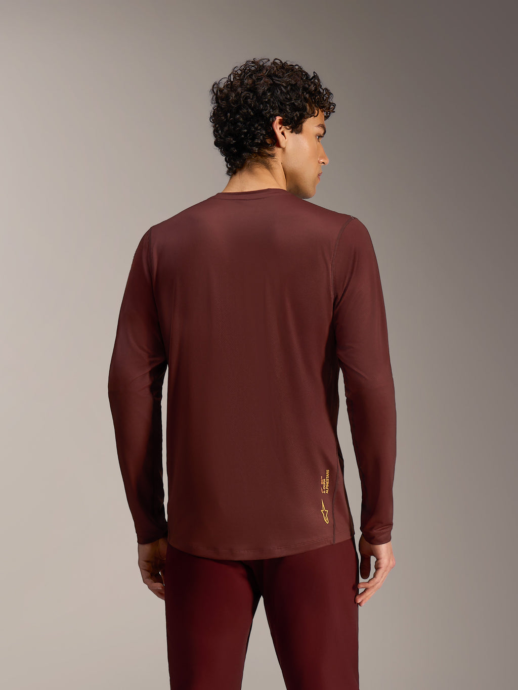 Maillot Alpinestars A-Dura Ride bordeaux, manches longues, vue de dos, tissu technique et ourlet arrière allongé.