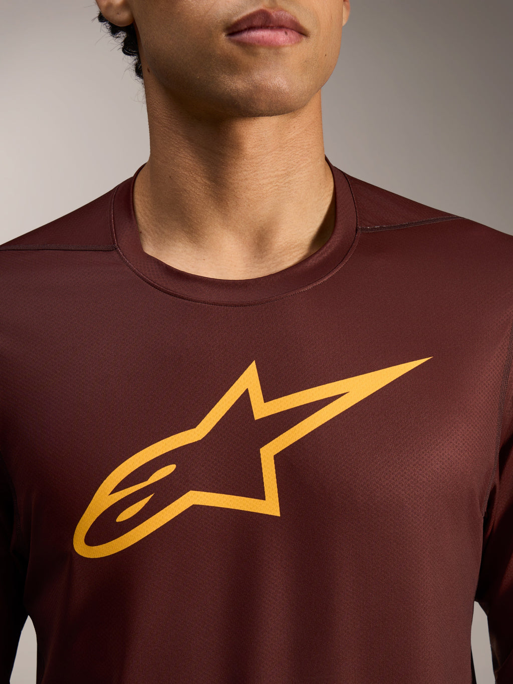 Maillot VTT A-Dura Ride bordeaux à manches longues, grand logo Astars jaune sur tissu jacquard haute performance.