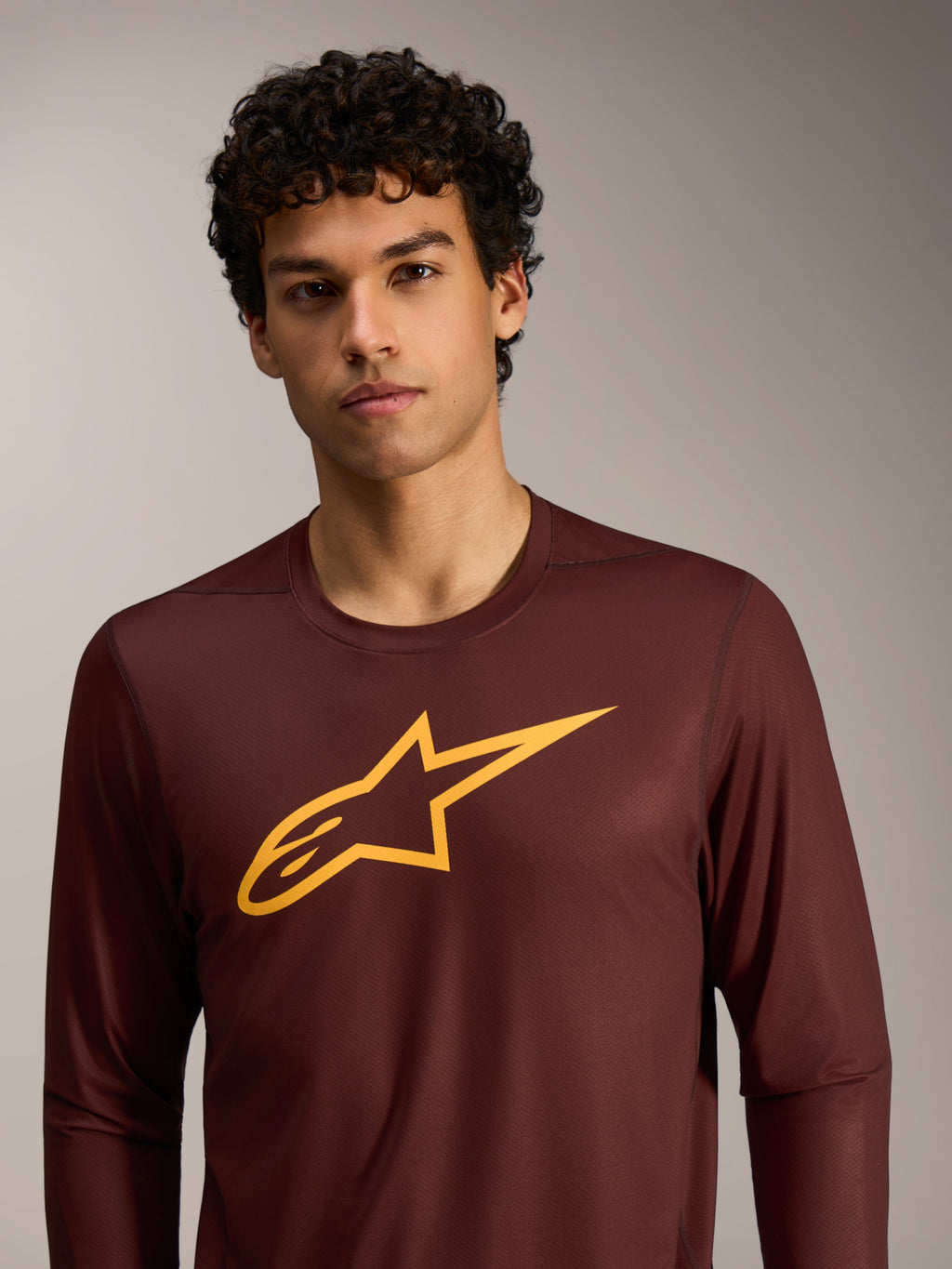 Maillot A-Dura Ride bordeaux à manches longues, logo Alpinestars jaune sur la poitrine, tenue de performance VTT.