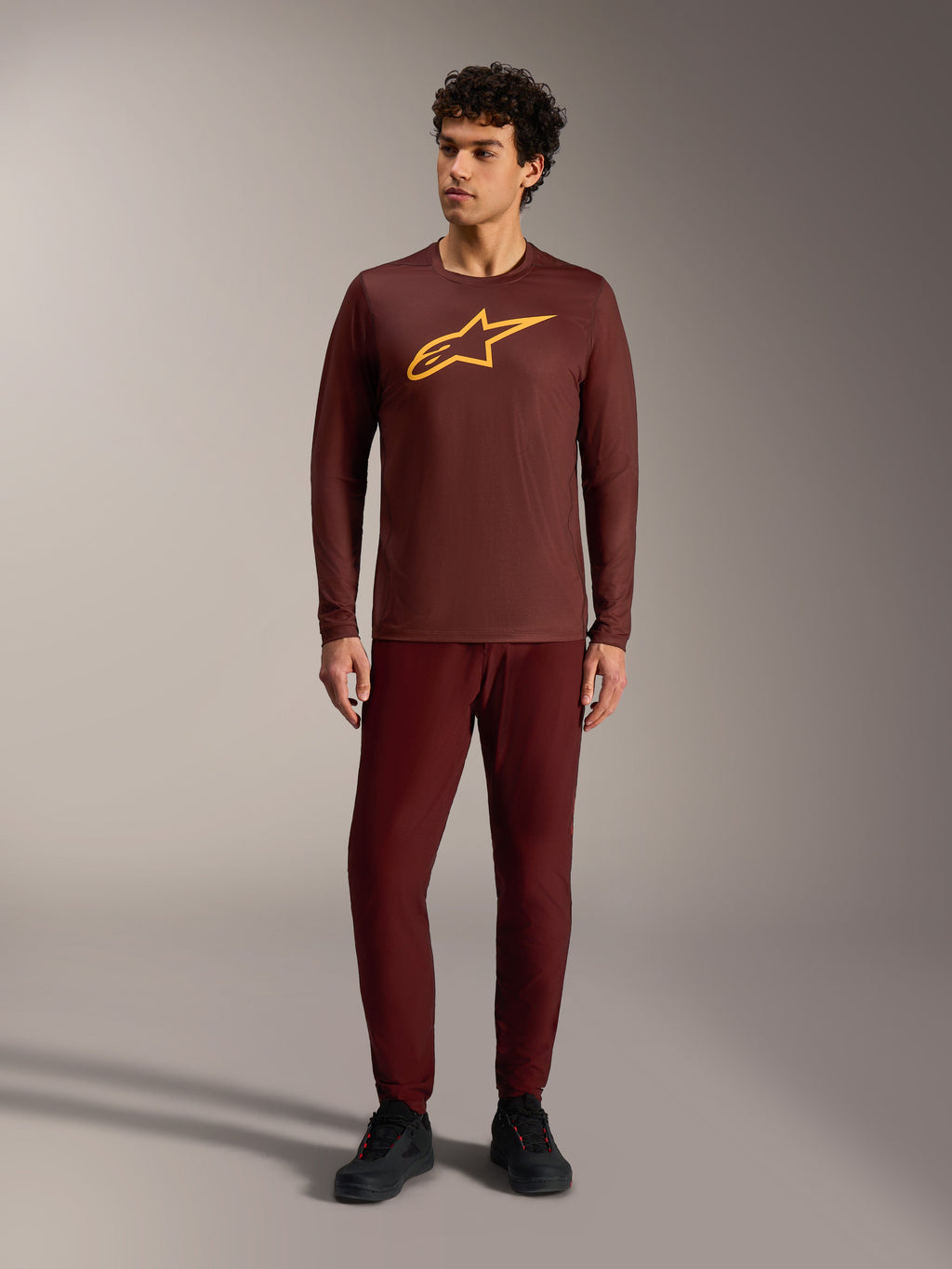 Maillot à manches longues A-Dura Ride bordeaux, logo Alpinestars jaune, pantalon assorti pour le VTT trail.