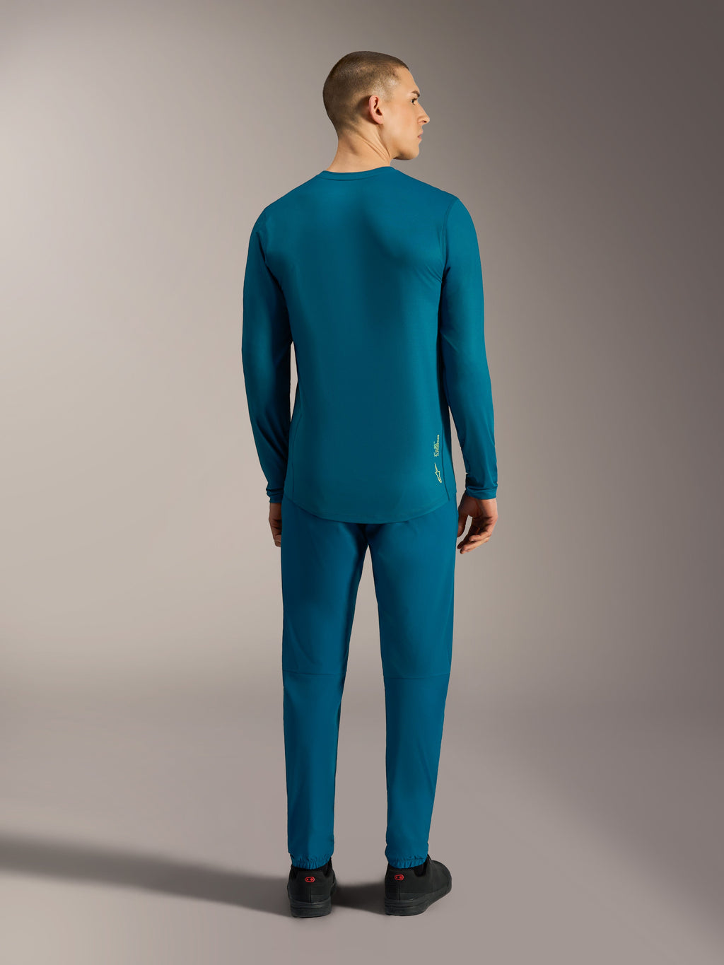 Maillot manches longues A-Dura Ride bleu-vert, vue de dos avec ourlet arrière tombant pour la performance en VTT.