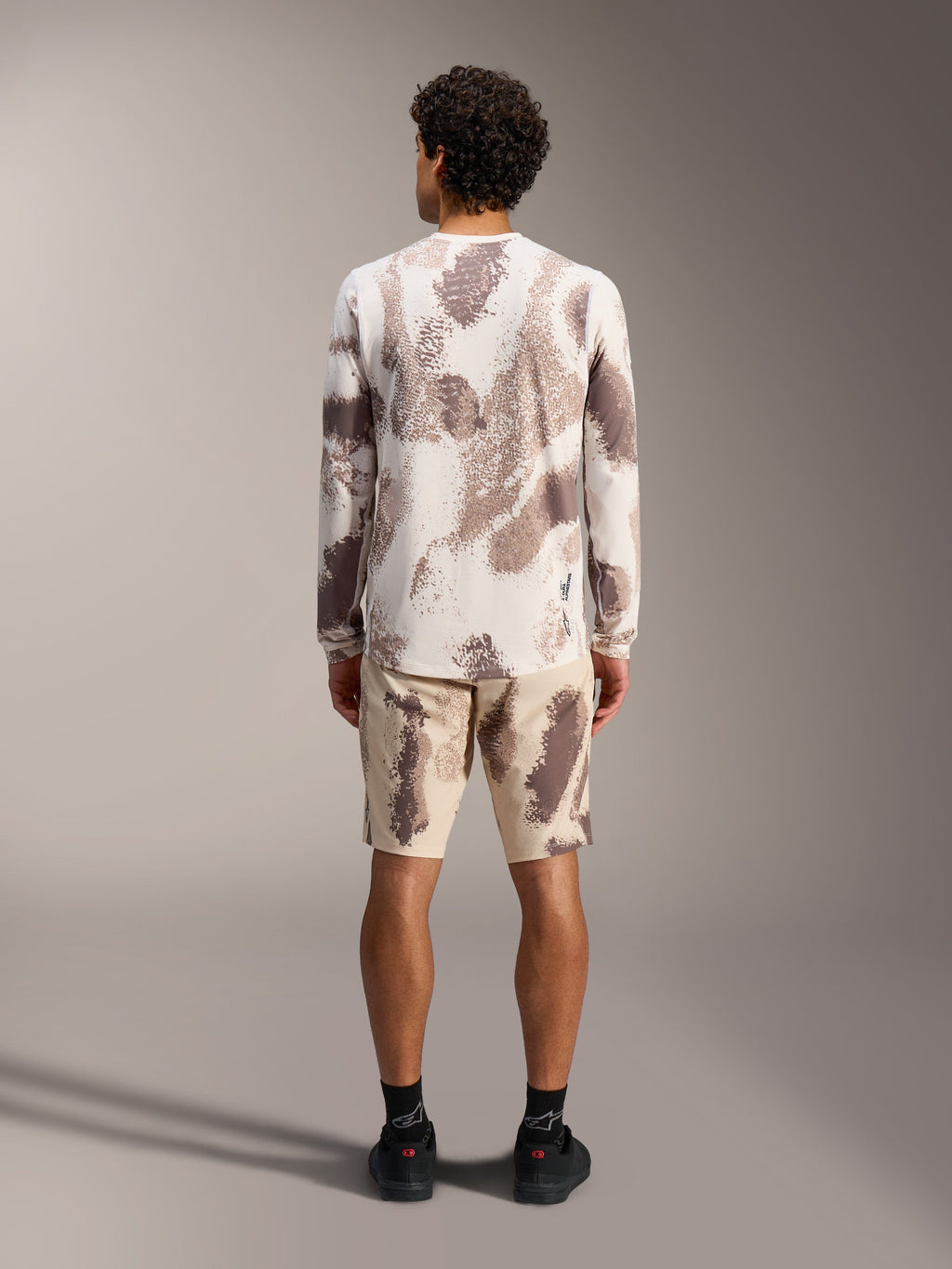 Maillot A-Dura Ride LS et short Alpinestars à motif camouflage sable, tenue de VTT complète, vue de dos.