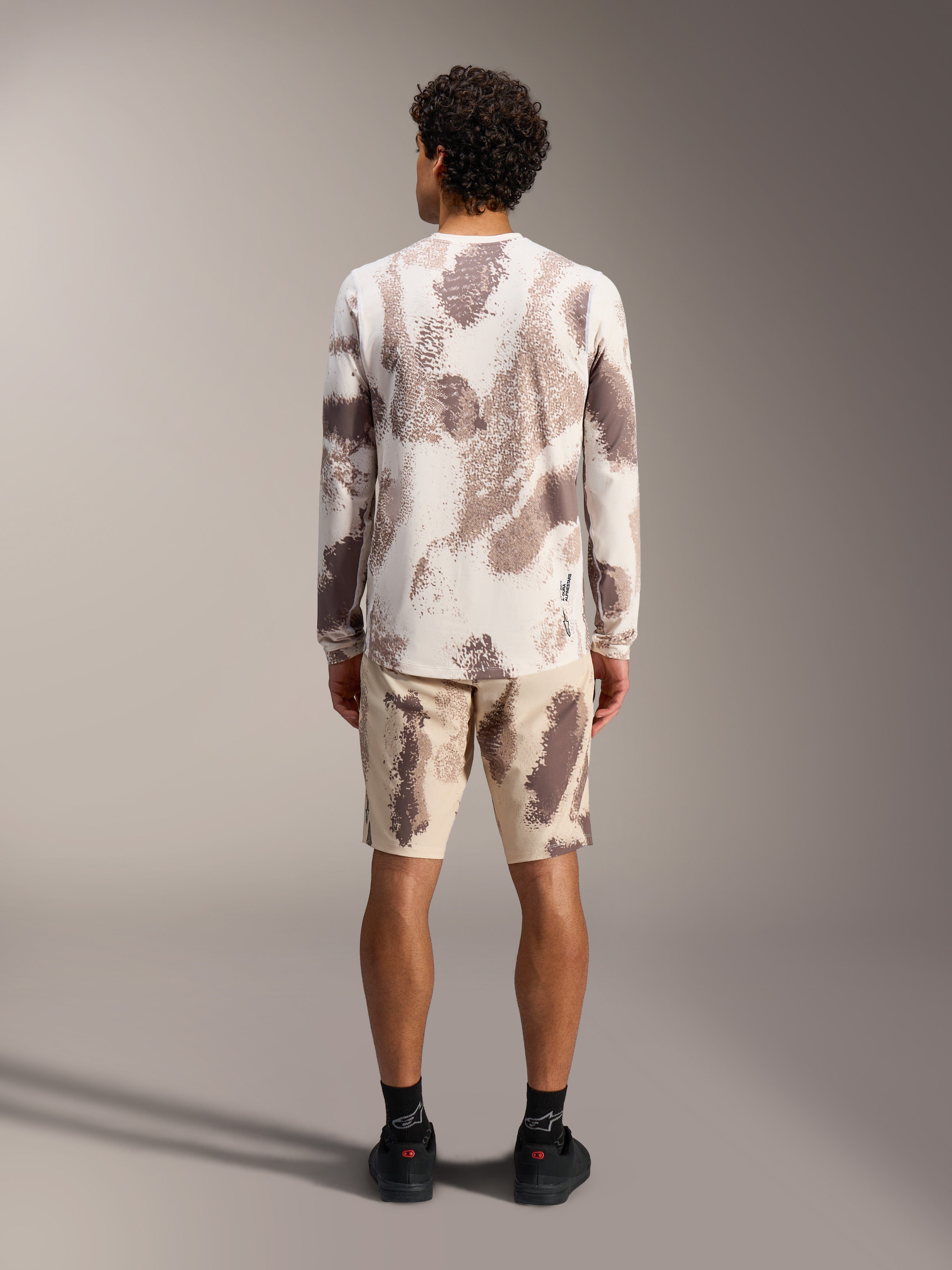 Maillot A-Dura Ride LS et short Alpinestars à motif camouflage sable, tenue de VTT complète, vue de dos.
