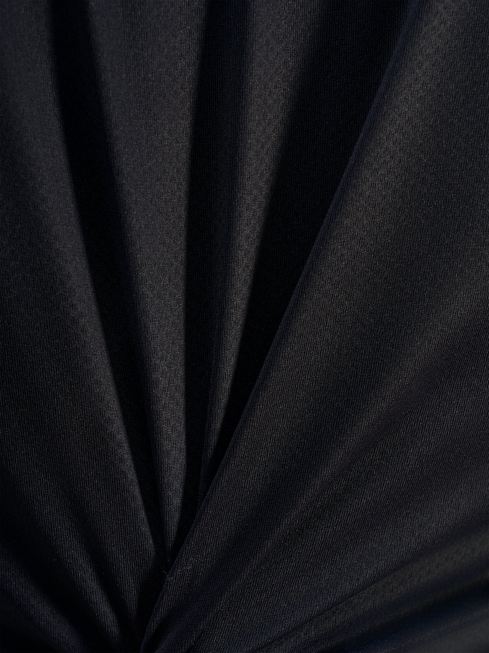 Black technical jacquard fabric detail of the A-Dura Ride Jersey, showcasing the breathable poly-spandex weave.