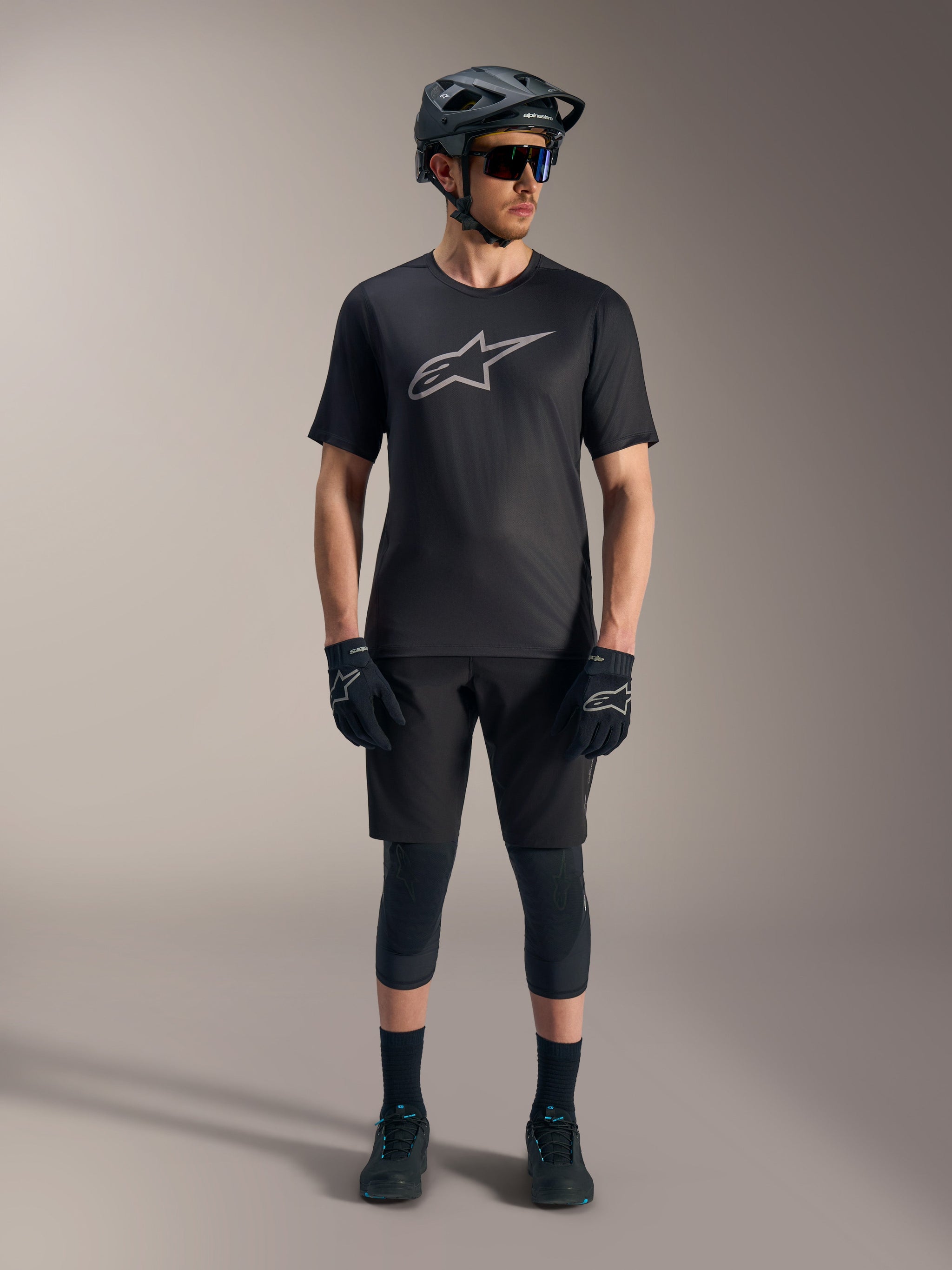 Black A-Dura Ride Short Sleeve Jersey with a silver chest logo, shown with a full Alpinestars MTB riding kit.