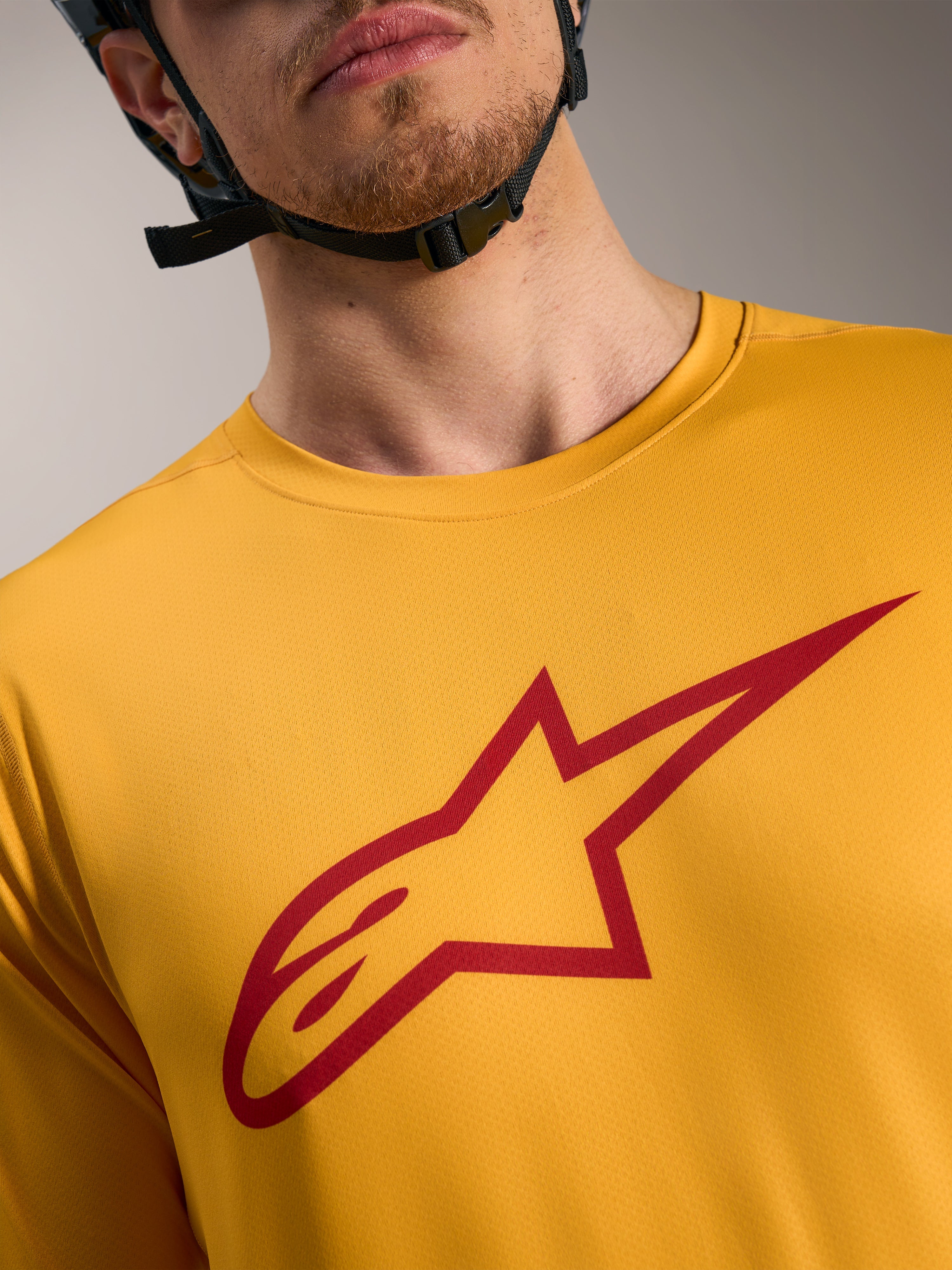 Maillot A-Dura Ride orange Alpinestars, logo Astars rouge sur la poitrine, vêtement technique léger pour le VTT.