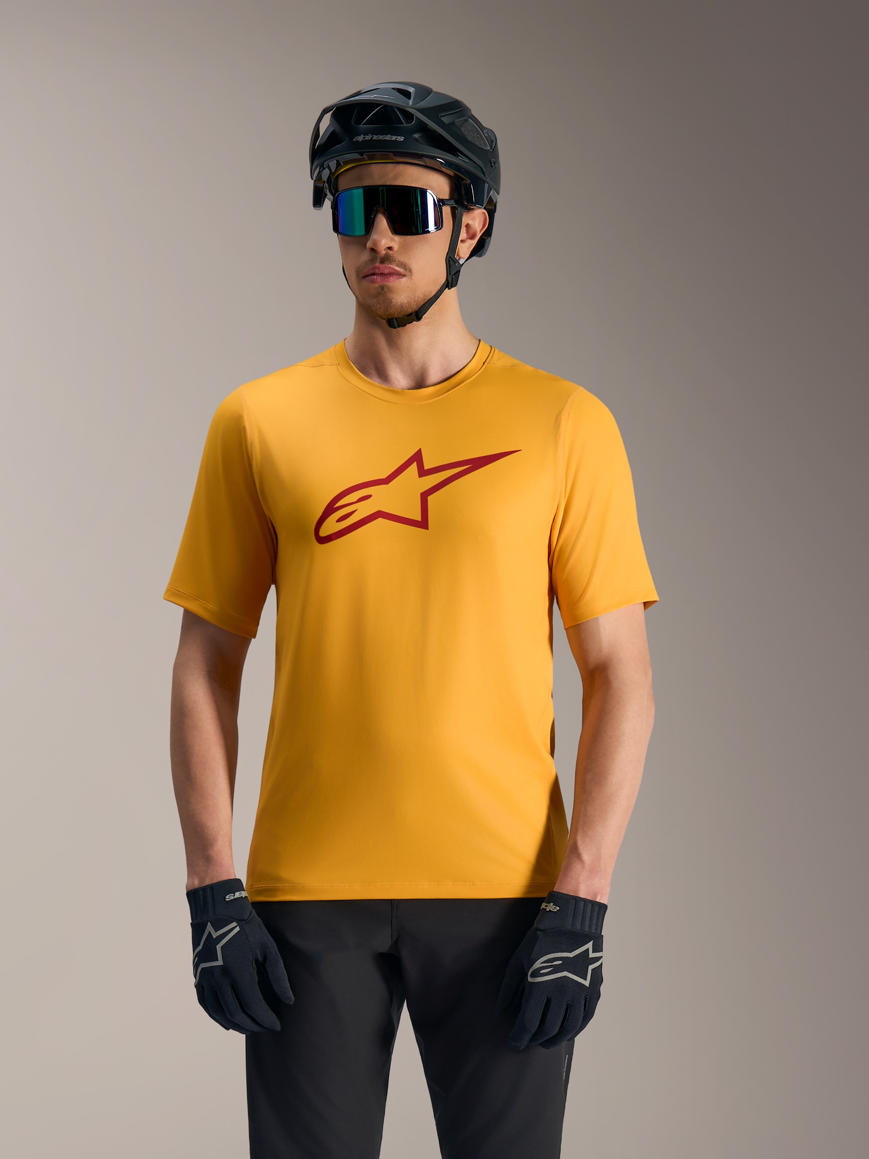 Maillot de VTT Alpinestars A-Dura Ride orange à manches courtes, logo Astars rouge, casque et gants de protection