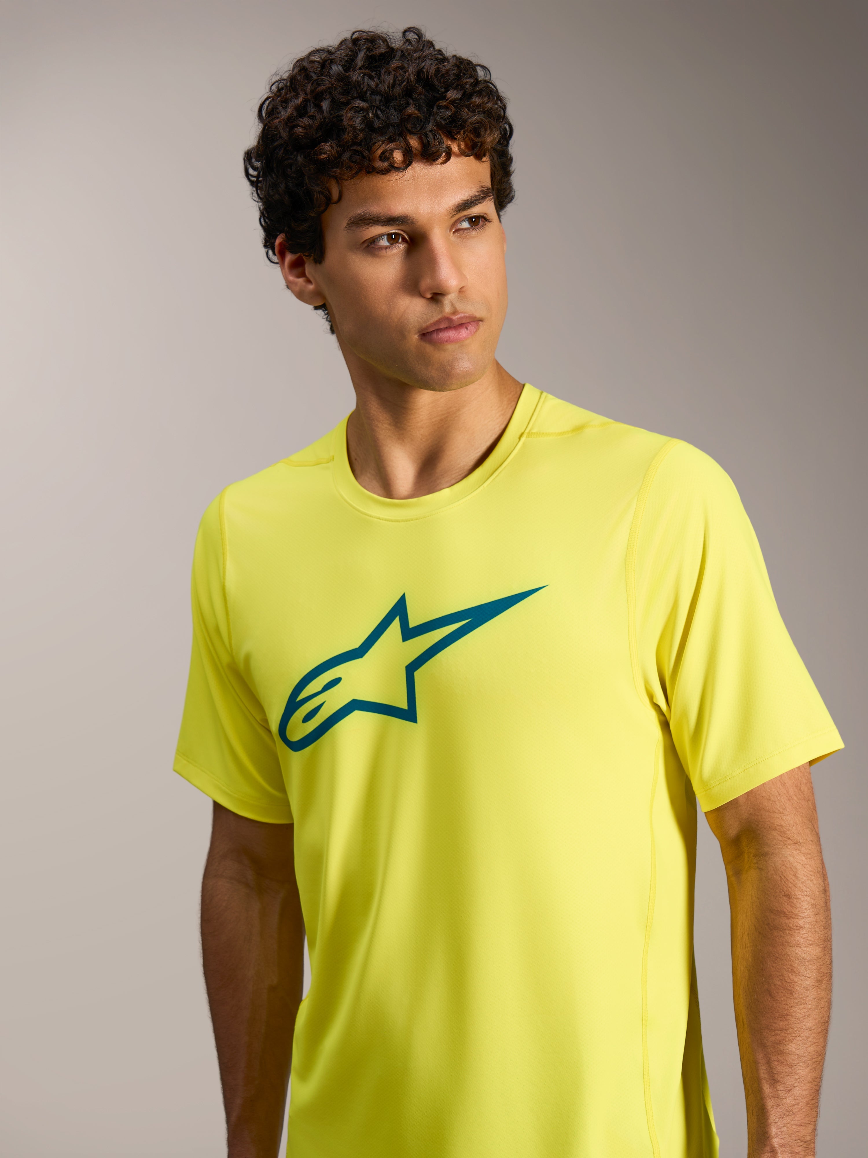 Maillot A-Dura Ride jaune fluo à manches courtes, logo Astars sarcelle sur la poitrine, idéal pour le VTT.