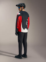 Maillot A-Dura Race rouge à manches longues, graphismes Alpinestars audacieux, vu de dos en tenue de VTT.