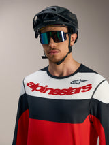 Maillot à manches longues A-Dura Race rouge, noir et blanc avec logo, porté avec casque VTT noir et lunettes.