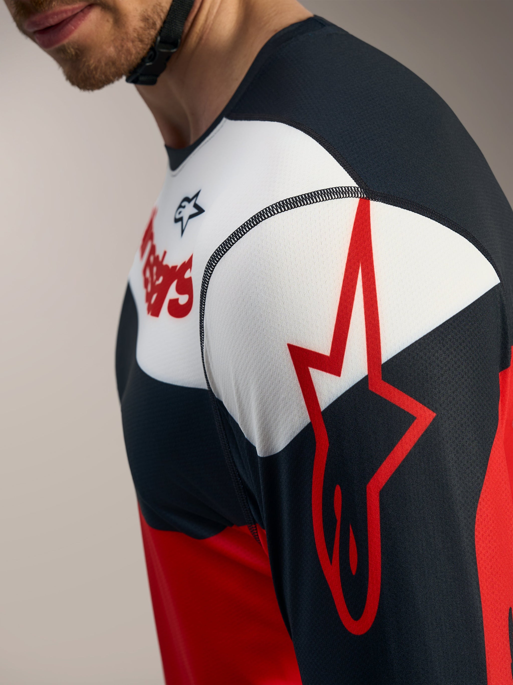 Maillot A-Dura Race manches longues Alpinestars, vue détaillée rouge et noir avec logo étoile sur la manche.