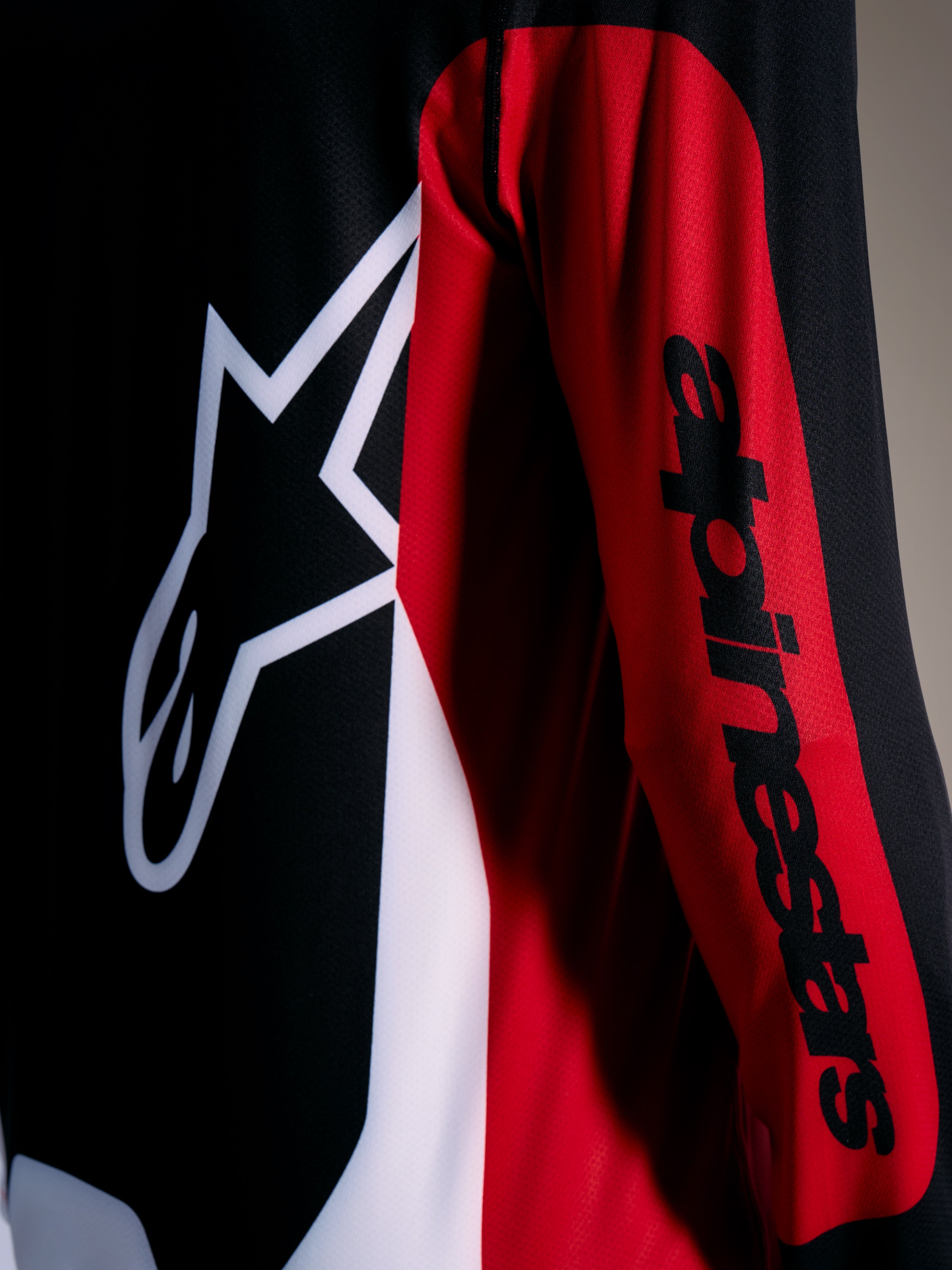 Maillot A-Dura Race rouge, logo Astars blanc et lettrage noir sur la manche, équipement VTT de performance.