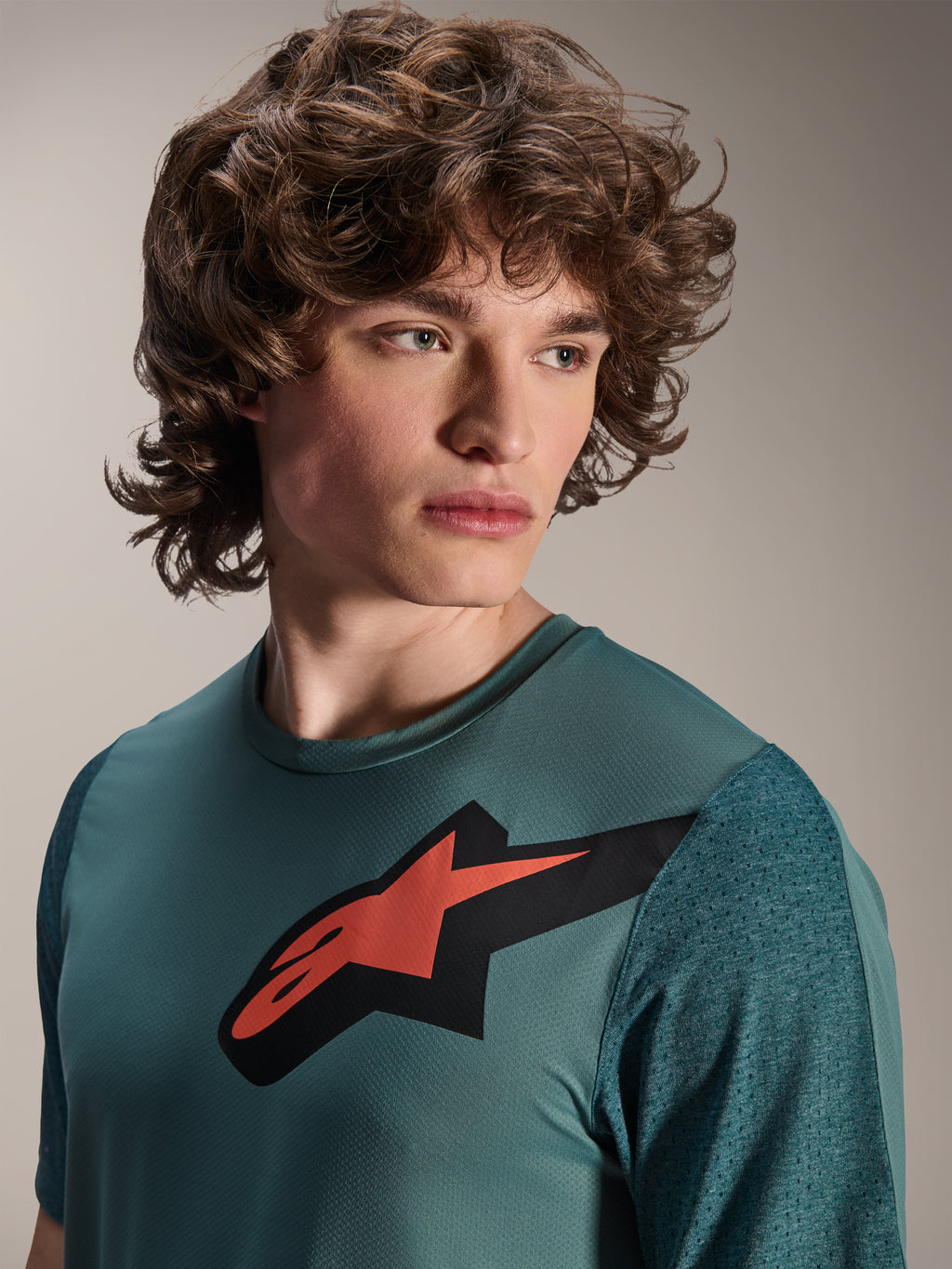 Alpinestars A-Dura Lipan Jersey, Short Sleeve MTB Jersey, Silver Pine, features a prominent red and black Astars logo on the chest, textured jacquard sleeves, close-up portrait of model wearing performance cycling gear
