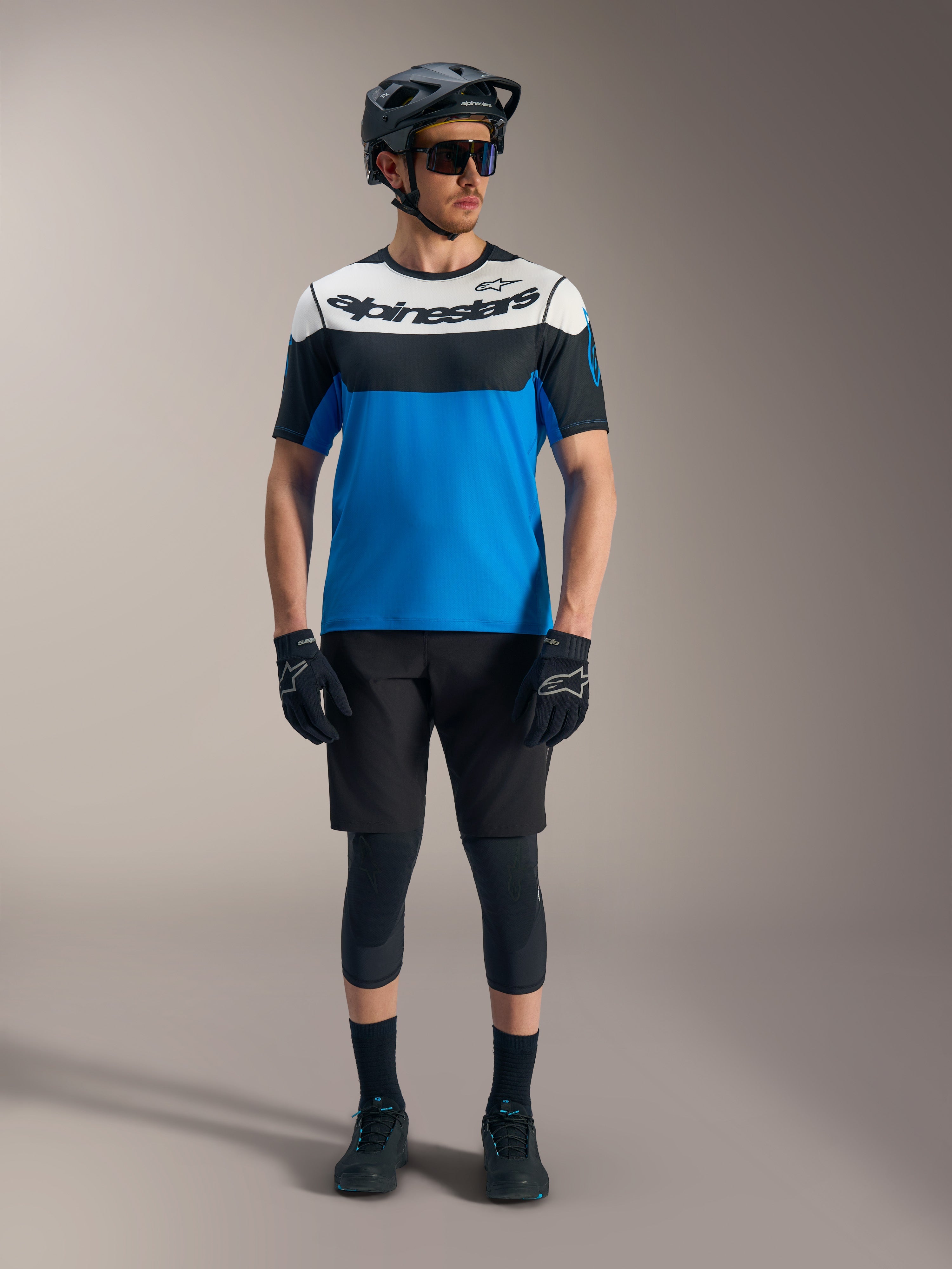 Maillot A-Dura Race SS et short Ride Alpinestars, tenue de VTT bleue et noire avec casque et protections.