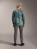 Alpinestars A-Dura Hollow Camo Jersey - Long Sleeve, Silver Pine Camo green camouflage pattern, worn by model from behind with grey technical pants, performance mountain bike apparel