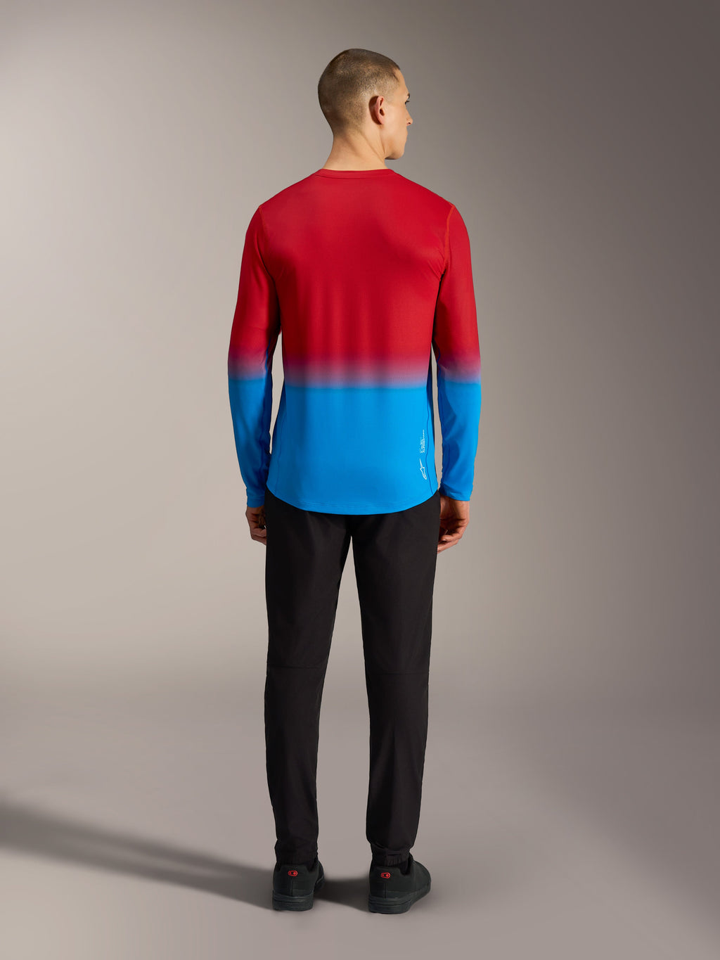 Maillot VTT Alpinestars A-Dura ASTARS 2.0, manches longues avec dégradé rouge et bleu, vue de dos sur modèle.