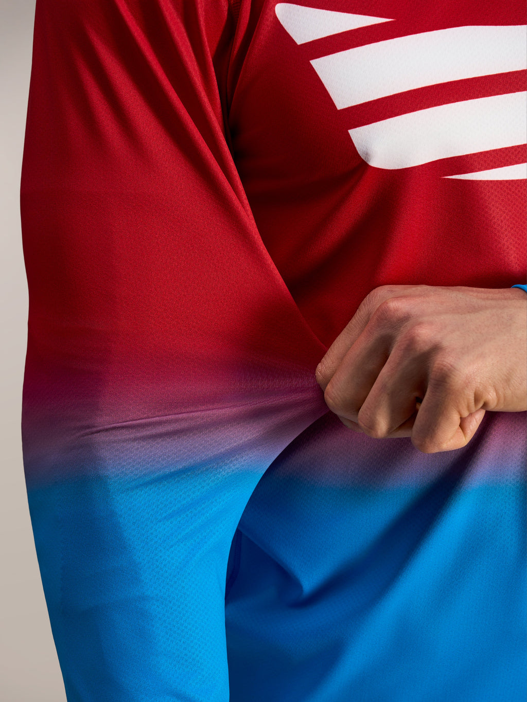 Tissu flexible rouge et bleu en poly-spandex du maillot Alpinestars A-Dura ASTARS 2.0 à manches longues.