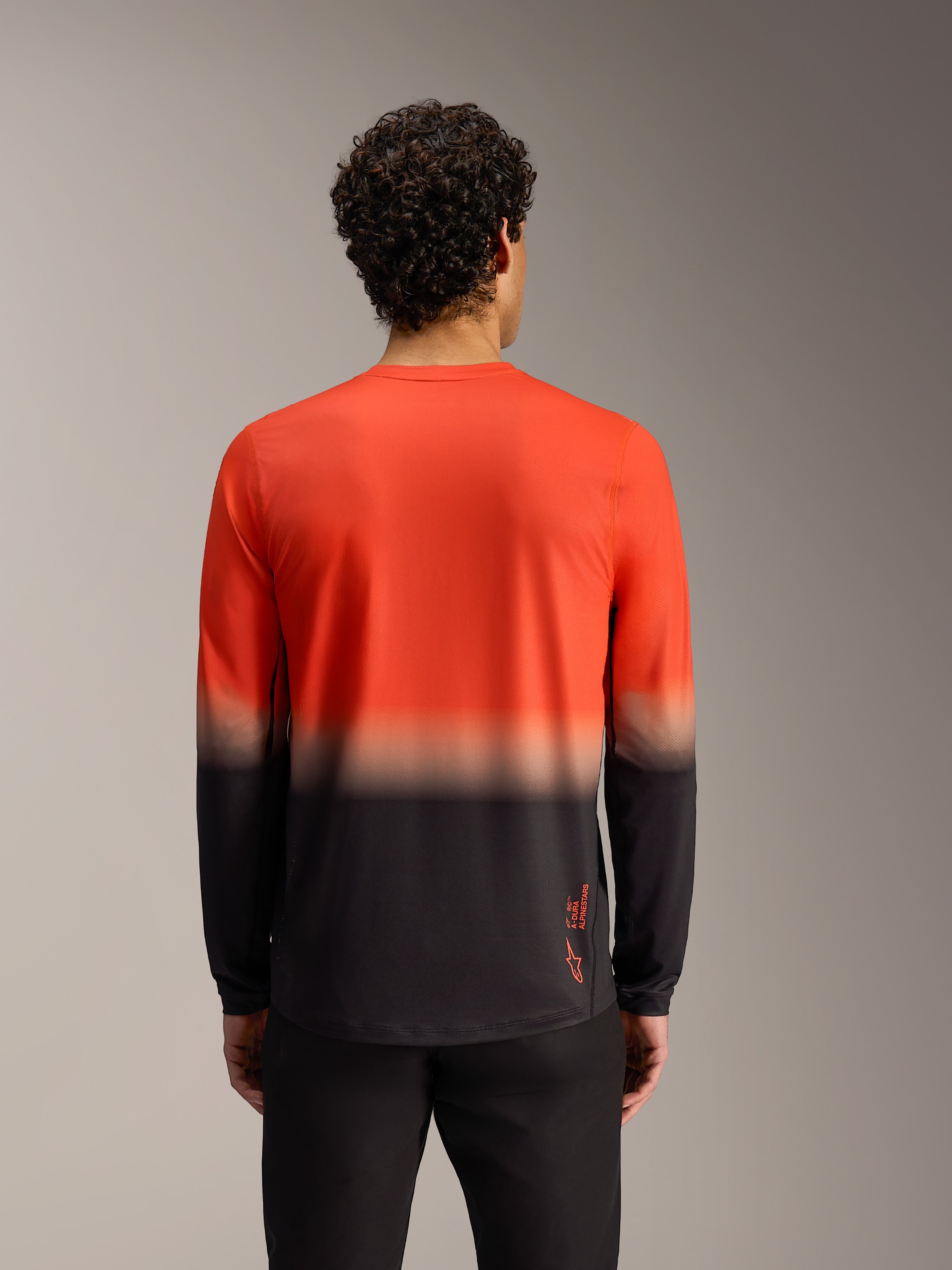 Maillot A-Dura ASTARS 2.0 à manches longues, dégradé orange et noir, vue de dos de cet équipement VTT performant.
