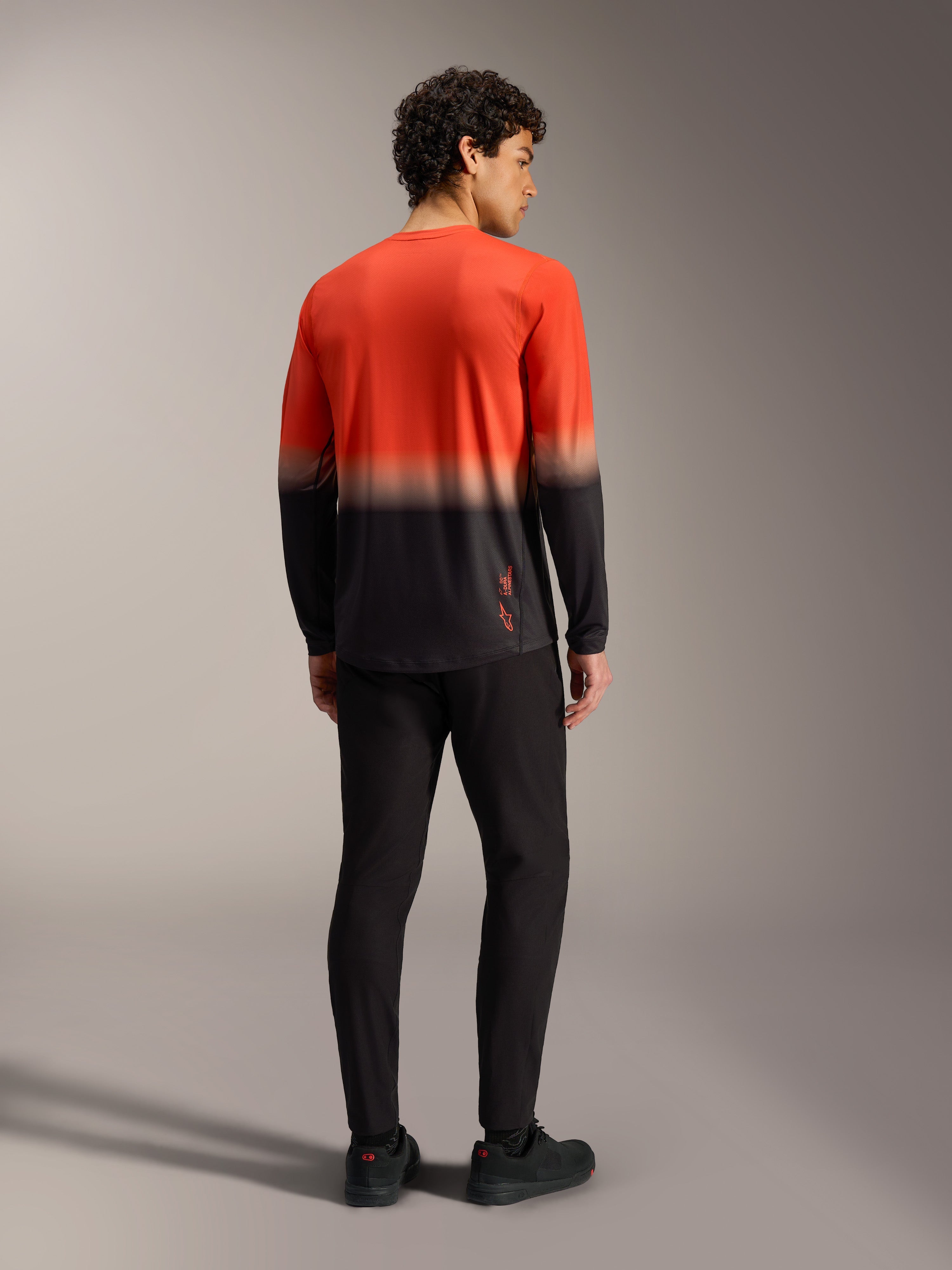 Maillot A-Dura ASTARS 2.0 manches longues en dégradé orange et noir, vêtement de VTT performant vu de dos.