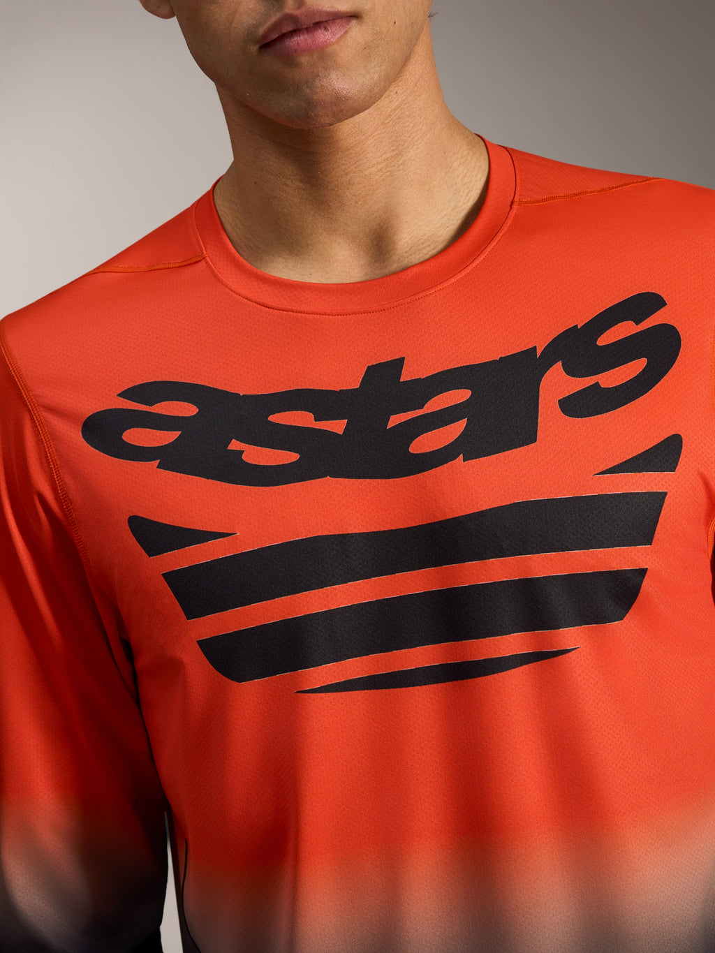 Maillot Alpinestars A-Dura ASTARS 2.0 orange et noir à manches longues, logo poitrine et tissu jacquard technique.