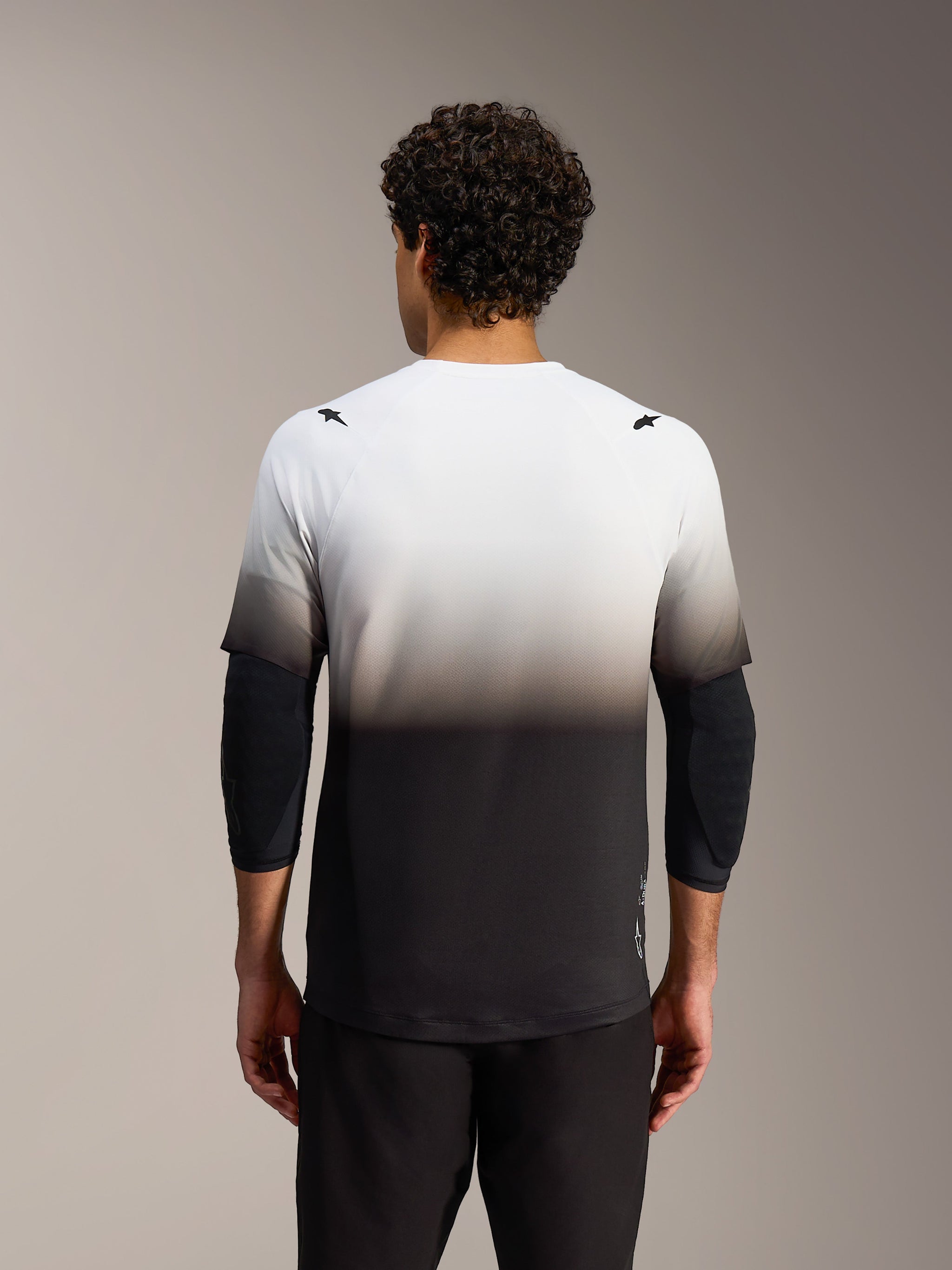 Maillot Alpinestars A-Dura ASTARS 2.0, dégradé blanc à noir, manches courtes et dos allongé pour la performance VTT.