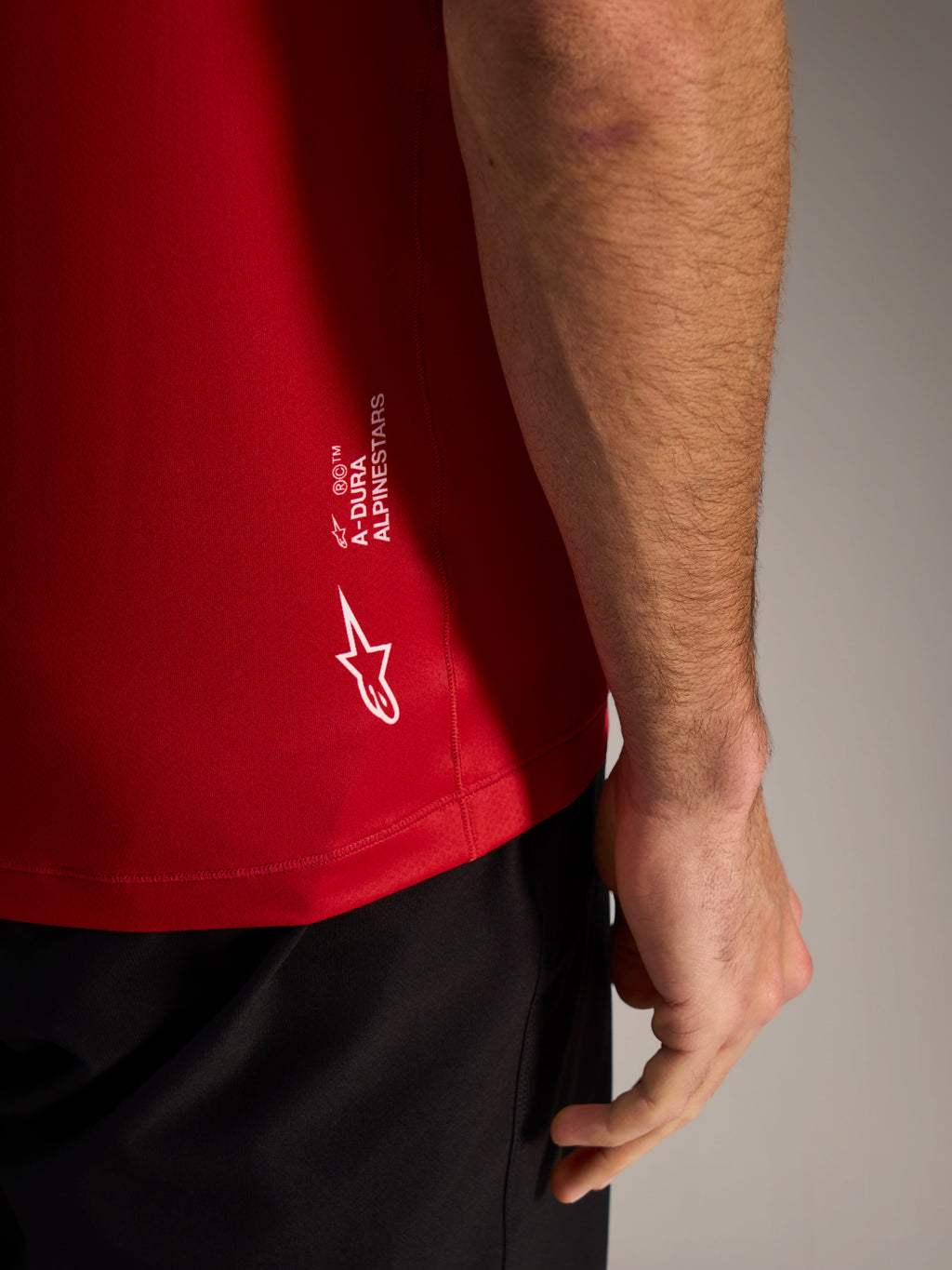 Maillot A-Dura ASTARS 2.0 rouge, gros plan sur le marquage blanc et le tissu jacquard respirant de VTT.