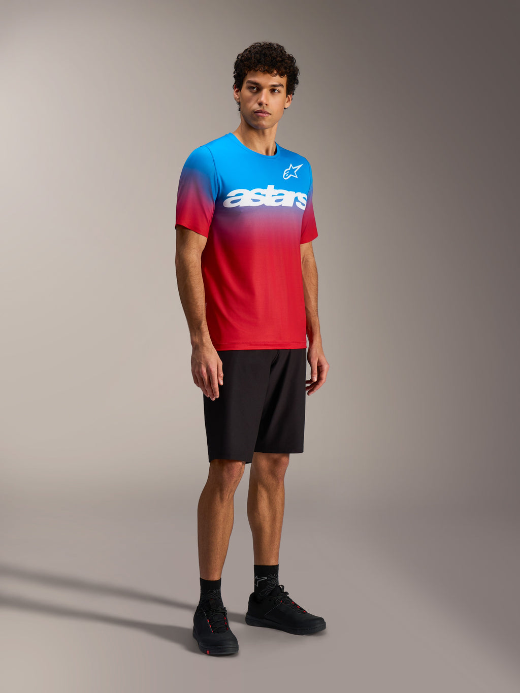 Maillot Alpinestars A-Dura ASTARS 2.0 dégradé rouge et bleu vif, manches courtes VTT avec logo blanc sur la poitrine.