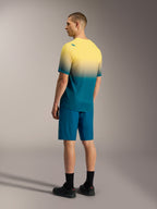 Maillot VTT A-Dura ASTARS 2.0 à manches courtes, dégradé jaune et bleu, avec short de performance bleu assorti.