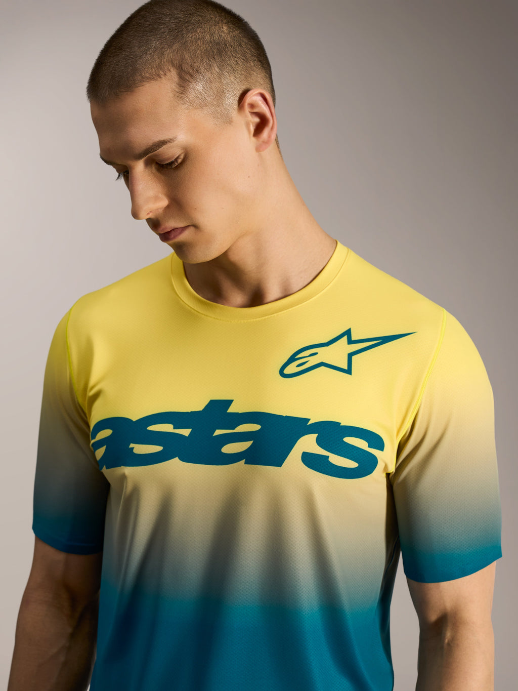 Maillot VTT A-Dura ASTARS 2.0, dégradé jaune et bleu à manches courtes, avec logo étoile et lettrage sur la poitrine.