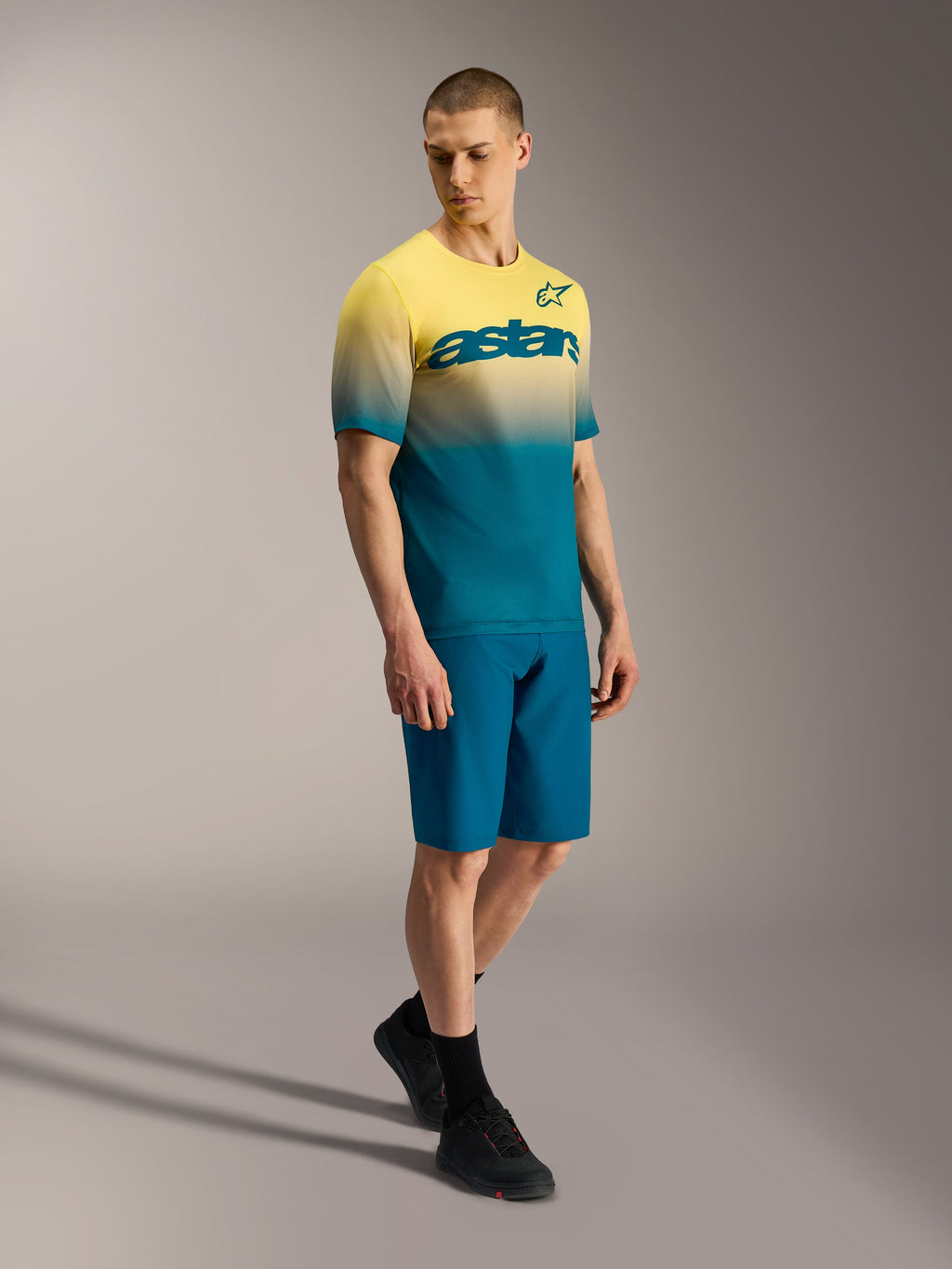Maillot VTT A-Dura ASTARS 2.0 à manches courtes, dégradé jaune et bleu avec logo poitrine sur un mannequin.