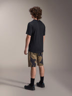 Maillot Alpinestars A-Dura Astar à manches courtes, noir, vu de dos, avec un short à motif camouflage, chaussettes et chaussures de sport noires, tenue de VTT décontractée