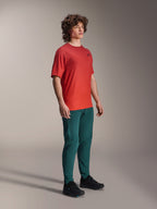 Modèle portant le pantalon Alpinestars A-Dura en Dark Pine, associé à un maillot à manches courtes A-Dura Rise rouge et des chaussures de VTT noires, vêtements de VTT sportifs dans un studio