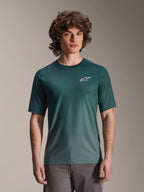 Alpinestars A-Dura Rise Jersey - Manches courtes, vert foncé Silver Pine, porté par un mannequin, avec logo Astars blanc sur la poitrine, tissu jacquard léger évacuant l'humidité, maillot de performance décontracté pour le VTT