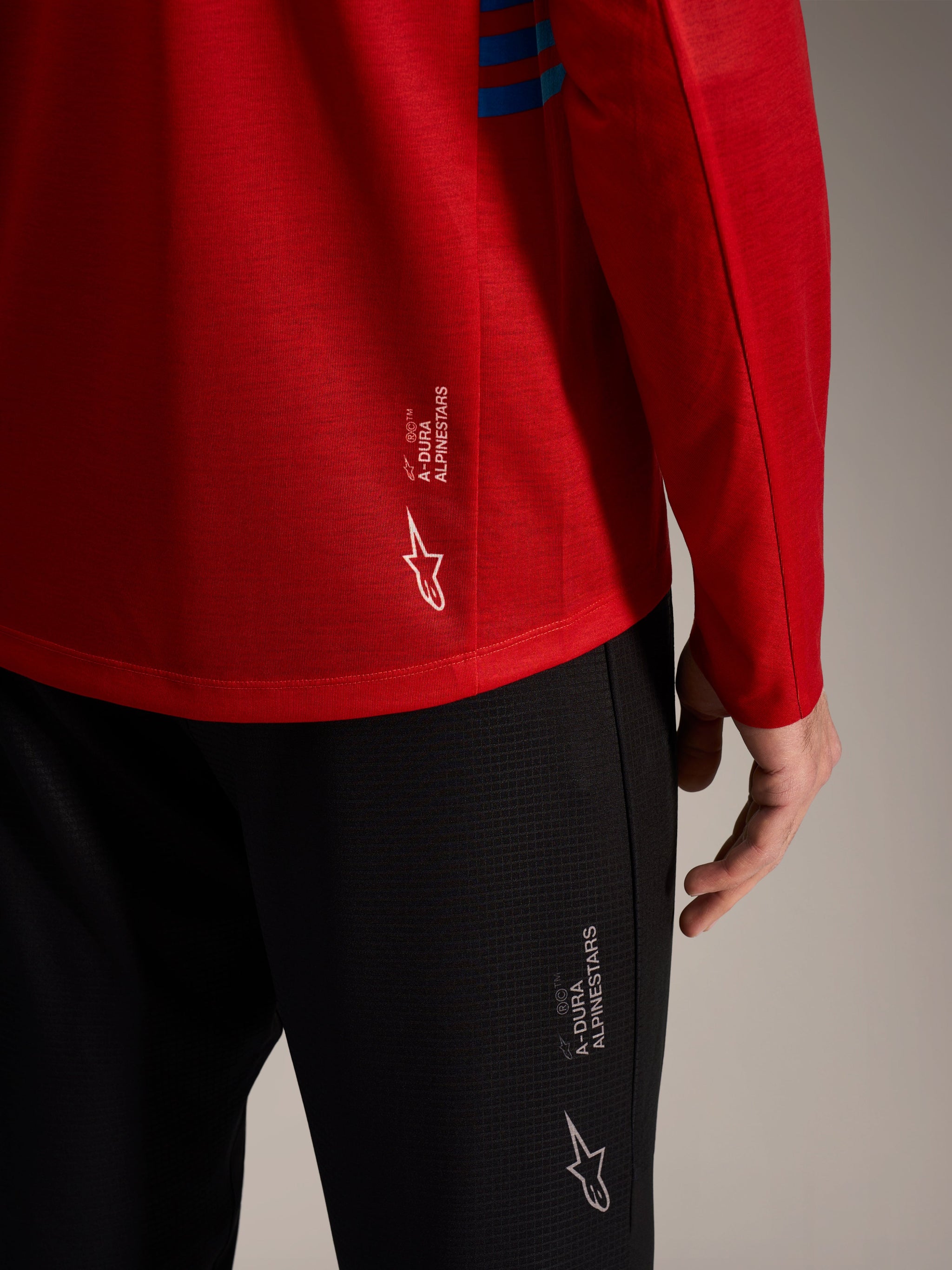 Red A-Dura Elite Long Sleeve Jersey 2.0 and black MTB pants featuring branded Alpinestars logos and performance fabric.
