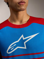 Maillot VTT Alpinestars A-Dura Elite 2.0 bleu et rouge, logo étoile blanc sur la poitrine.