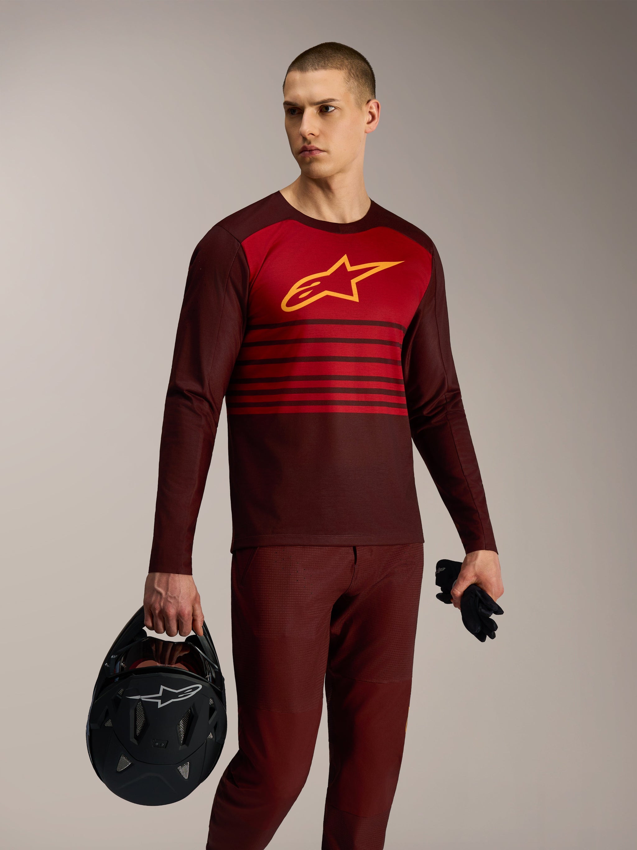 Maillot à manches longues A-Dura Elite 2.0 bordeaux et rouge, tenue de VTT avec logo Alpinestars jaune sur la poitrine.