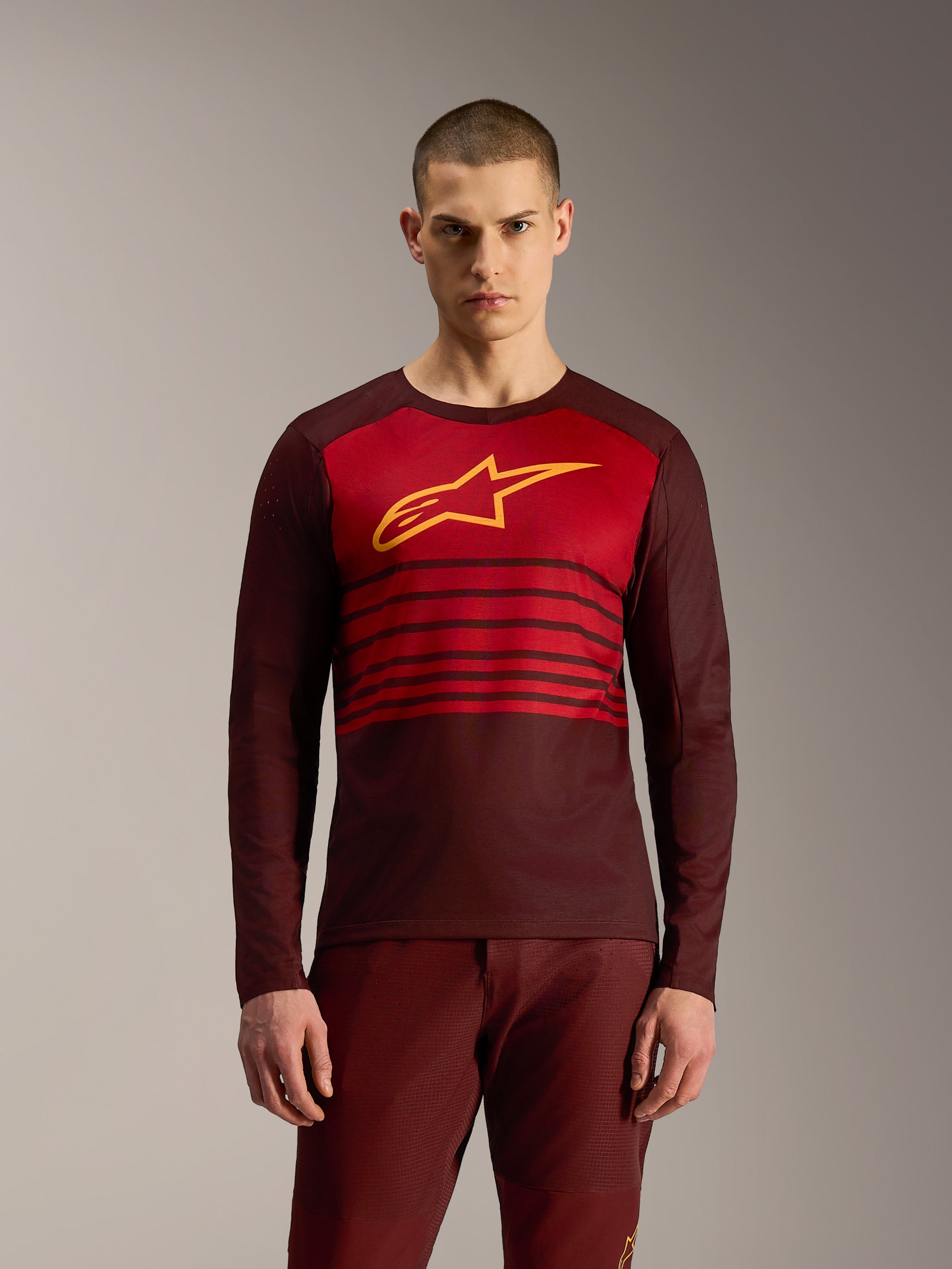 Maillot A-Dura Elite 2.0 bordeaux à manches longues, rayures horizontales et logo Alpinestars jaune pour le VTT.