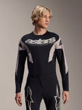 Alpinestars A-Supra Melt Jersey à manches longues, maillot de VTT, noir et gris, avec le graphisme « astars » sur la poitrine et des manches à motifs, porté avec un pantalon de performance assorti