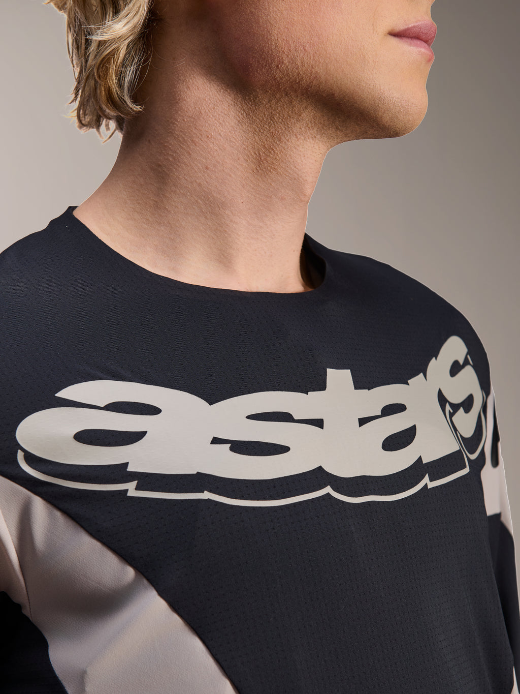 Maillot Alpinestars A-Supra Melt, maillot de VTT à manches longues, noir et gris avec un grand logo astars blanc sur la poitrine, tissu respirant micro-perforé, design inspiré de la course