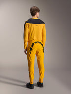 Maillot Alpinestars A-Supra Melt Gold Édition Limitée, maillot de VTT à manches longues, jaune foncé avec panneau noir aux épaules, porté avec un pantalon jaune assorti arborant un logo noir imposant à l'arrière, vue arrière d'une tenue de cyclisme de performance