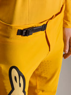 Pantalon Alpinestars Limited Edition A-Supra Melt Gold, pantalon de VTT, jaune foncé, gros plan sur le système de fermeture à cliquet noir à la taille, avec perforations laser sur l'intérieur de la cuisse pour la ventilation