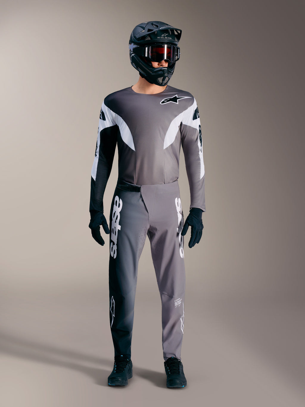 Alpinestars A-Supra Elite MTB gear in faded gray, featuring performance jersey and pants with bold white logos.