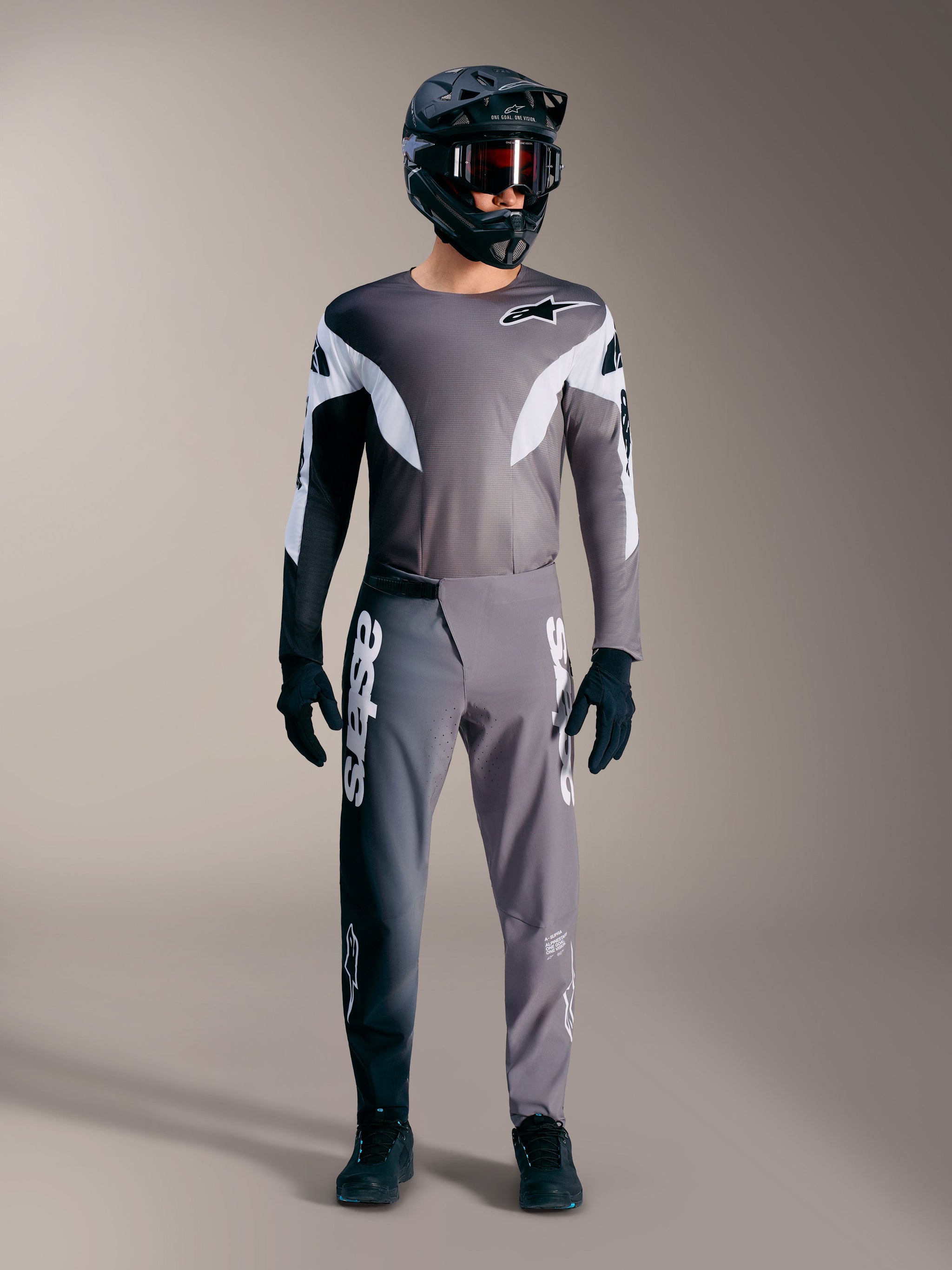 Tenue VTT Alpinestars A-Supra Elite gris dégradé, avec maillot et pantalon de performance aux logos blancs audacieux.