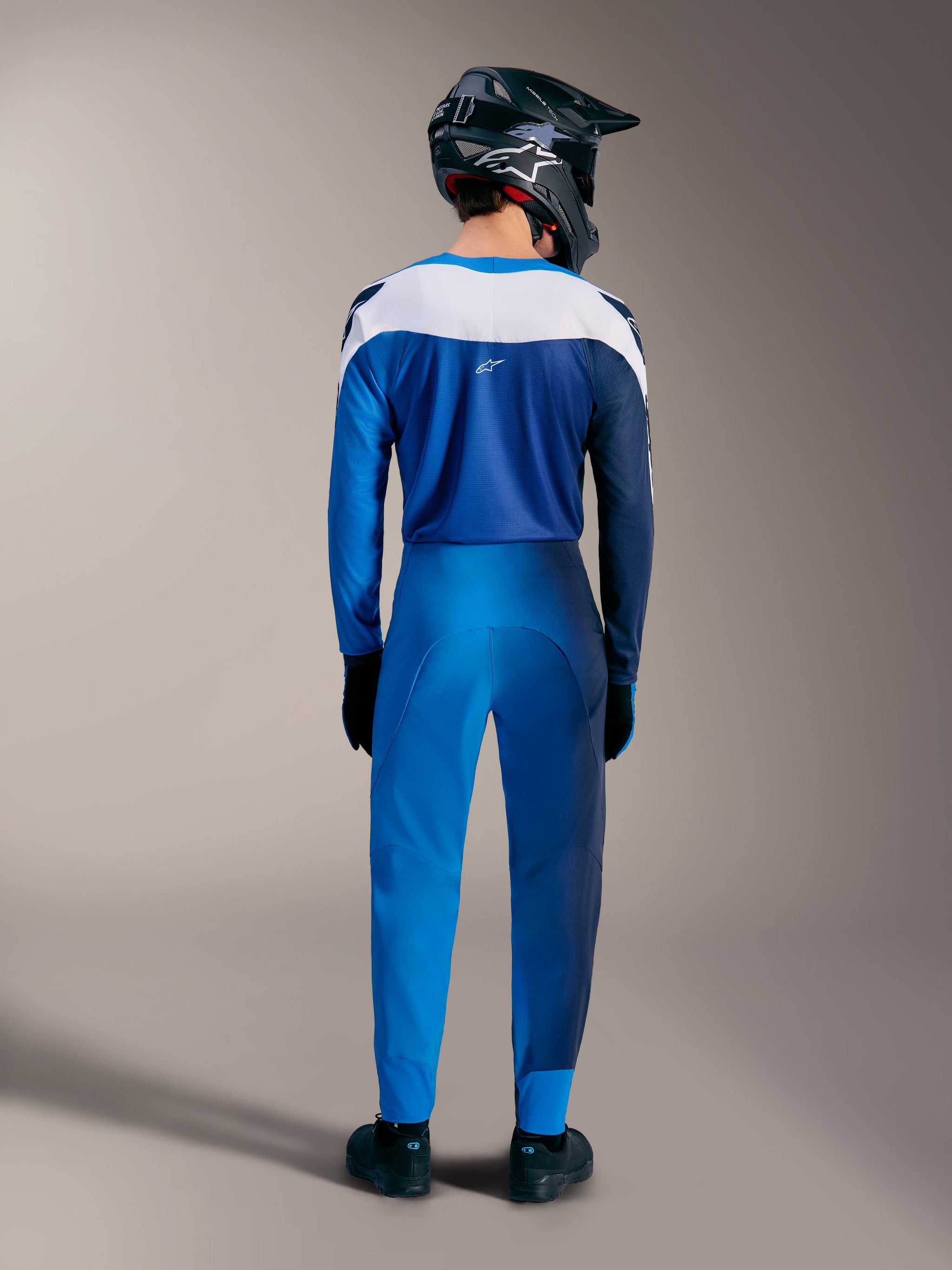 Ensemble VTT A-Supra Elite bleu vif dégradé, vue arrière du maillot et du pantalon technique à empiècements blancs.