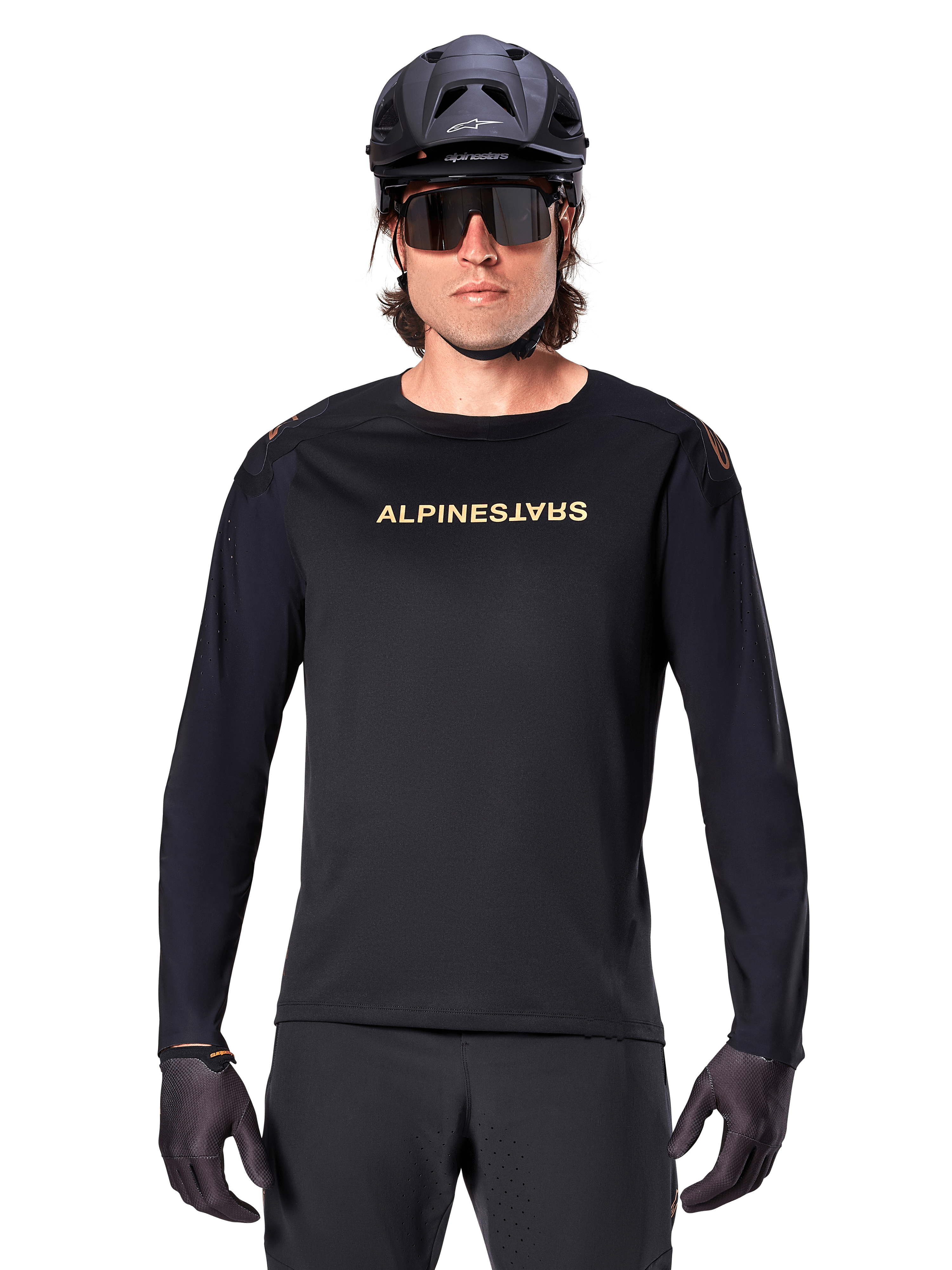 Alpinestars A-Aria Polartec Switch Long Sleeve Jersey, Black, gold Alpinestars logo on chest, worn with a black MTB helmet, dark sunglasses, and black gloves, professional mountain bike trail gear